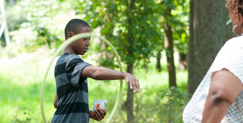 A young boy plays with a hula hoop