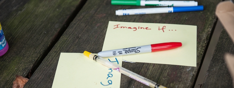 Photo of markers and sticky notes on a picnic table.